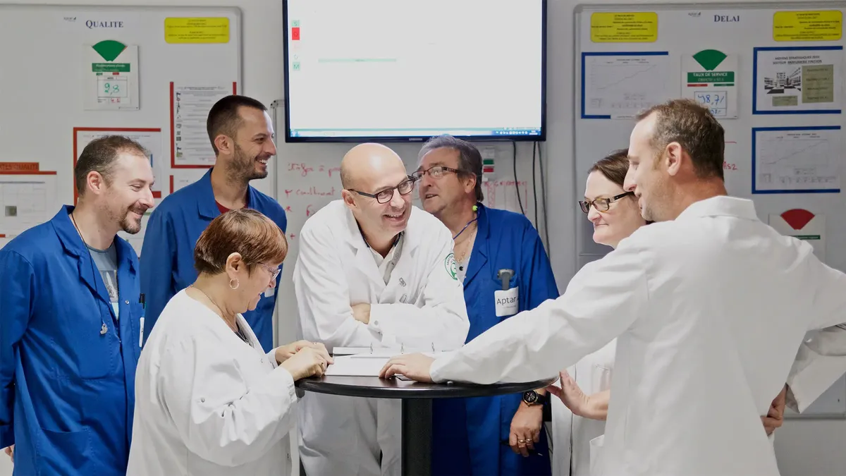 A group of Aptar Employees at a site in Le Noubourg France working together in the quality lab